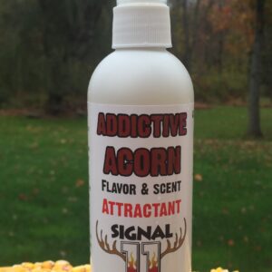 A bottle of attractant signal is sitting on the grass.