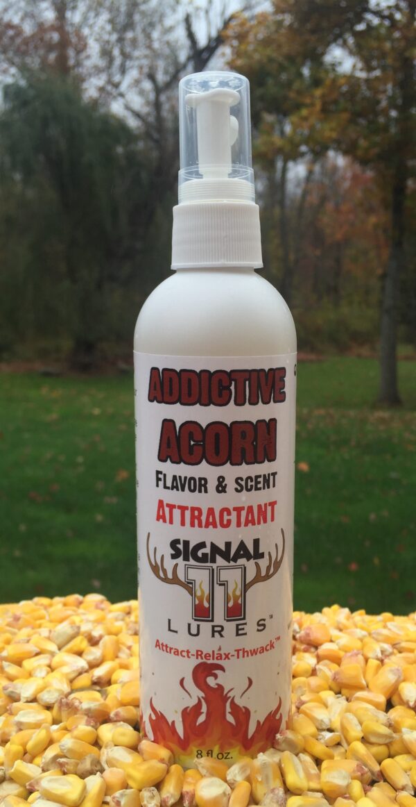 A bottle of attractant signal is sitting on the grass.