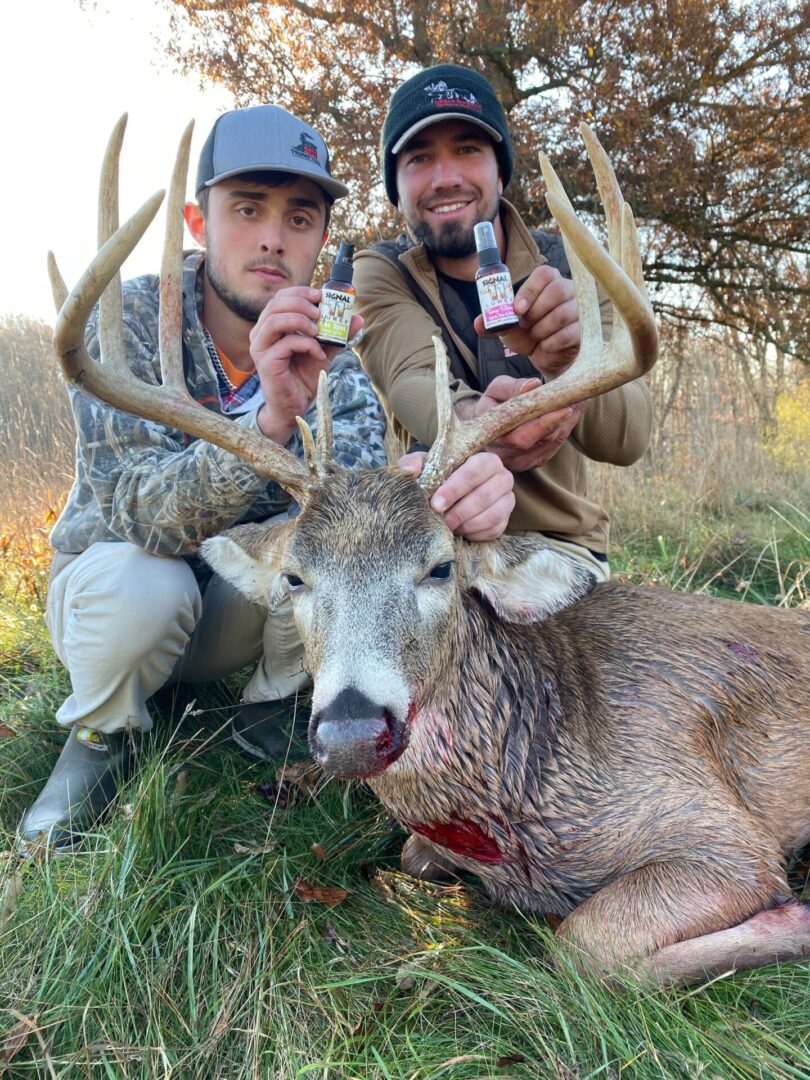 Two men with guns and a trophy deer