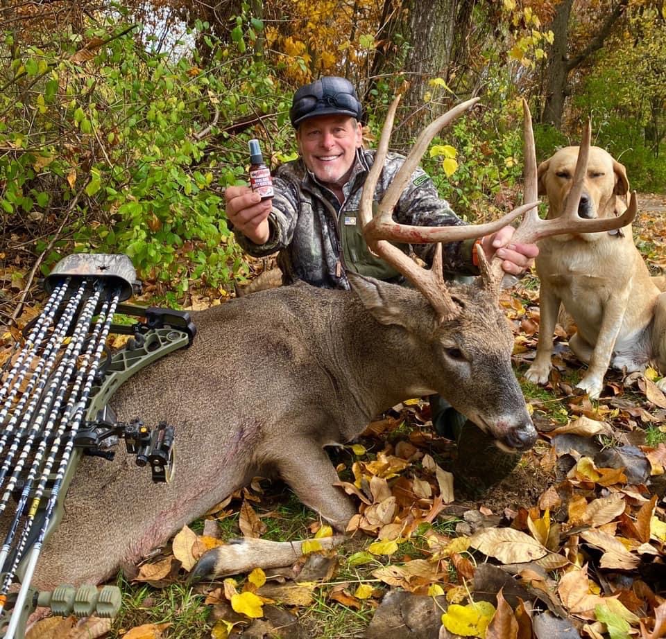 A man and his dog pose with their trophy deer.